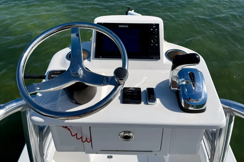 Slide: The Image of 2019 Aquasport 244 Bay boat helm with steering wheel and controls. - 19
