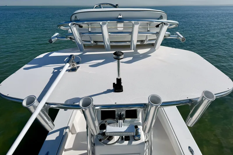 Slide: The Image of 2019 Aquasport 244 Bay boat with rod holders on deck, floating on calm water. - 20