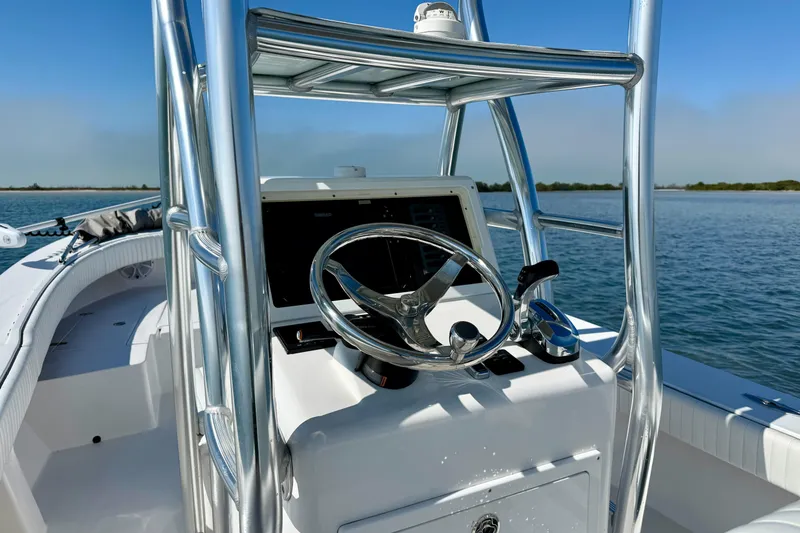 Slide: The Image of 2019 Aquasport 244 Bay boat steering console on calm water. - 21
