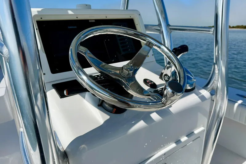 Slide: The Image of 2019 Aquasport 244 Bay boat steering wheel and control panel on open water. - 23