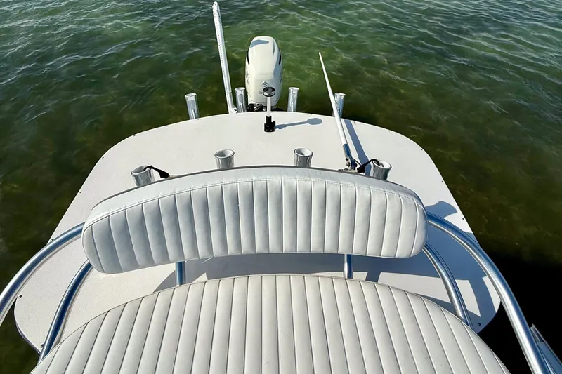 Slide: The Image of 2019 Aquasport 244 Bay boat interior with white seating, on calm water. - 24