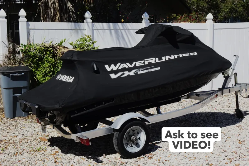 Slide: The Image of 2024 Yamaha WaveRunner VX Cruiser covered on a trailer, parked outdoors. - 2