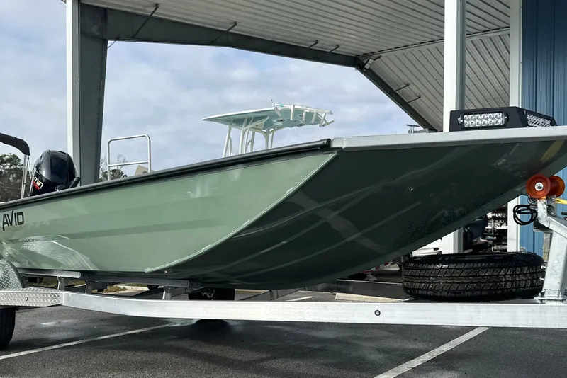 Slide: The Image of 2026 Avid 18 Commander boat on trailer under shelter, showcasing sleek design. - 12