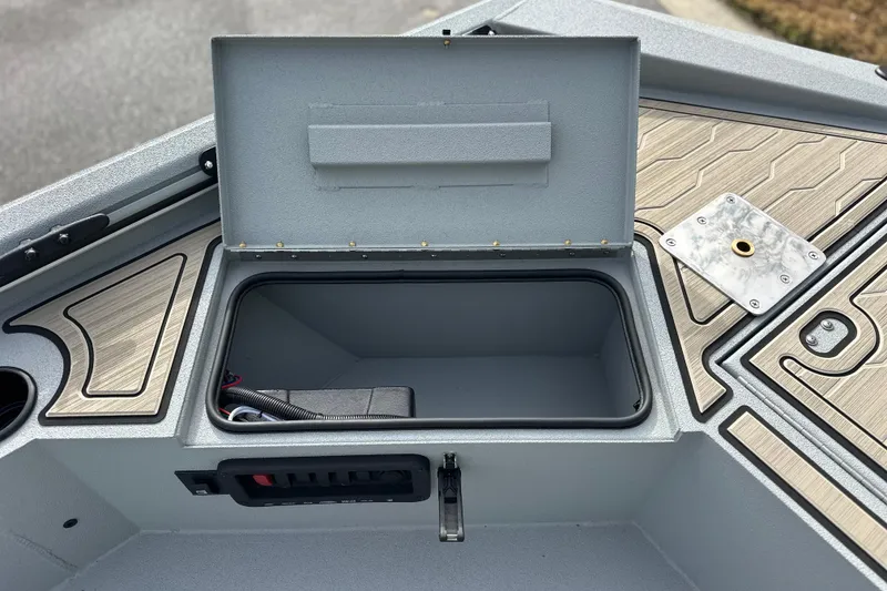 Slide: The Image of Open storage compartment on 2026 Avid 18 Commander boat, featuring sleek design and wood accents. - 16