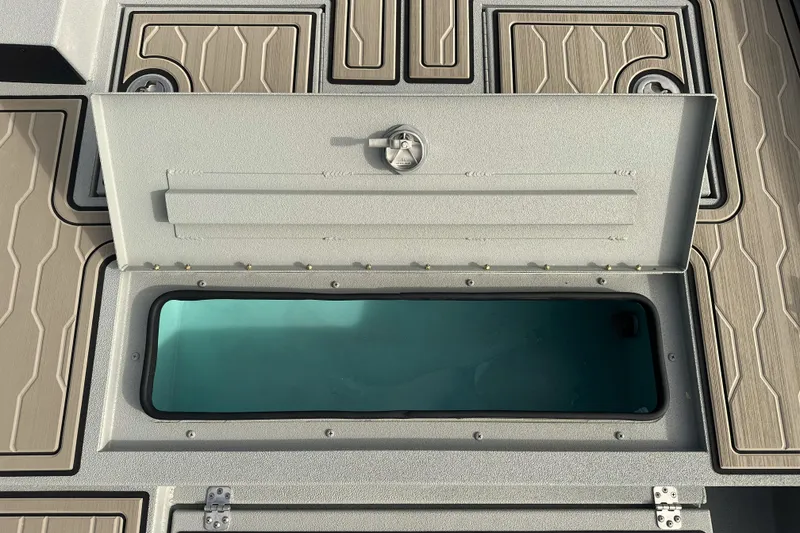 Slide: The Image of Open storage compartment on 2026 Avid 18 Commander boat with textured flooring. - 19
