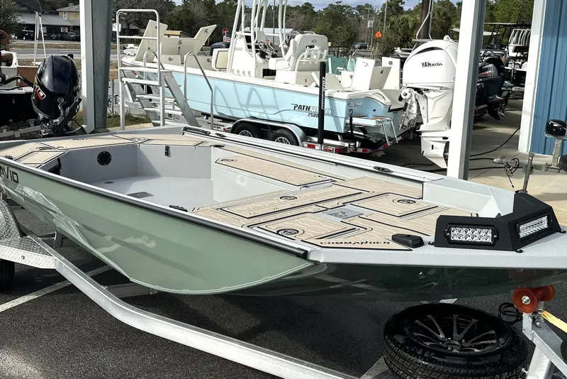 Slide: The Image of 2026 Avid 18 Commander boat on trailer, displayed outdoors at a dealership. - 2
