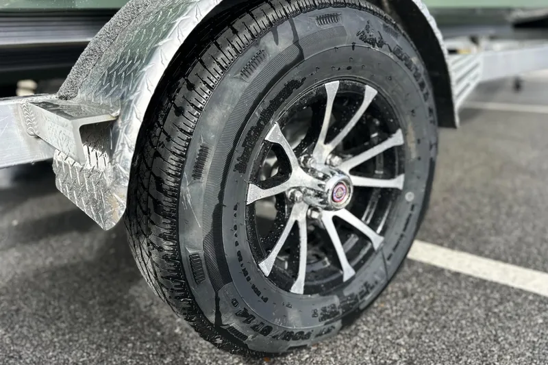 Slide: The Image of Close-up of a 2026 Avid 18 Commander trailer wheel on wet pavement. - 25