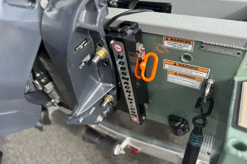 Slide: The Image of Close-up of 2026 Avid 18 Commander boat engine with warning labels and hardware. - 7