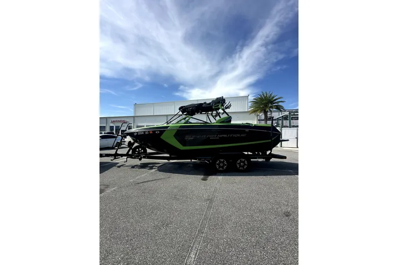 Slide: The Image of 2016 Nautique Super Air Nautique G23 Coastal Edition boat on trailer, parked outdoors. - 13