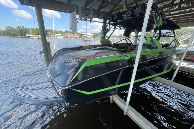 Slide: The Image of 2016 Nautique Super Air Nautique G23 Coastal Edition boat docked on a sunny day. - 2