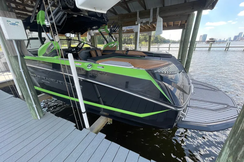 Slide: The Image of 2016 Nautique Super Air Nautique G23 Coastal Edition docked, featuring sleek black and green design. - 5