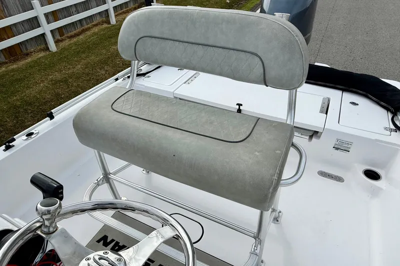 Slide: The Image of 2020 Sportsman Tournament 214 SBX Bay Boat helm seat with steering wheel, outdoor setting. - 10
