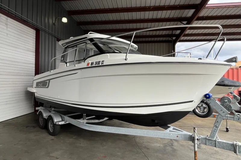 Slide: The Image of 2022 Jeanneau NC Weekender 695 Series 2 boat on trailer in covered storage. - 22