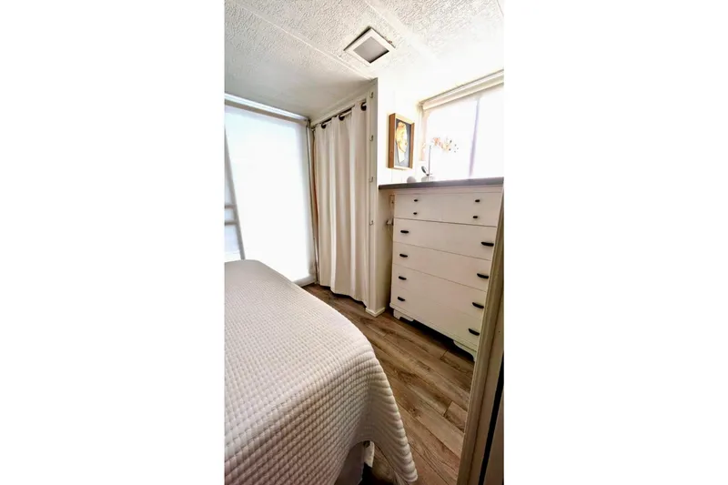 Slide: The Image of Cozy bedroom in 1986 Stardust Cruisers houseboat with plush bedding and sliding glass door. - 11