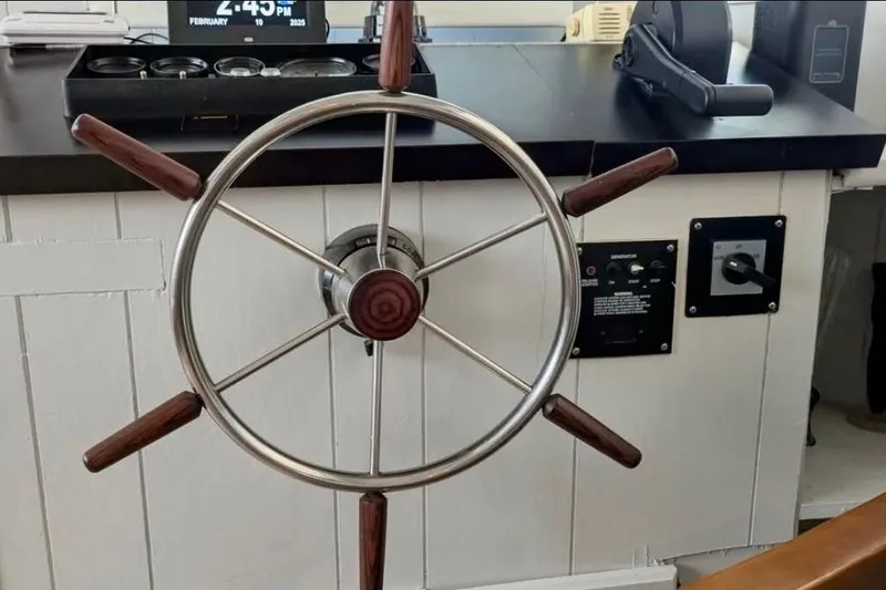 Slide: The Image of Steering wheel of a 1986 Stardust Cruisers 52 houseboat, featuring classic wooden handles. - 14