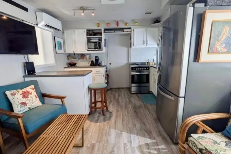 Slide: The Image of Interior of a 1986 Stardust Cruisers 52 houseboat, featuring cozy decor and modern appliances. - 3