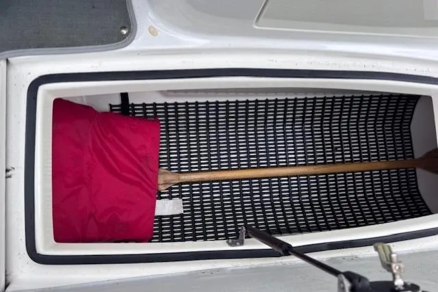 Slide: The Image of Storage compartment in 2009 Yamaha AR230 HO boat with paddle and red life jacket. - 15