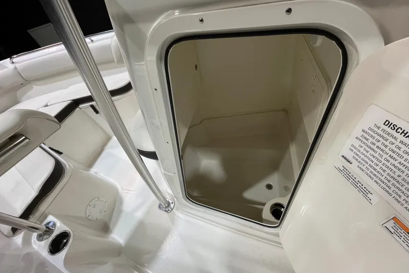 Slide: The Image of 2023 Sailfish 220 CC boat interior storage compartment with open hatch and safety notice. - 12
