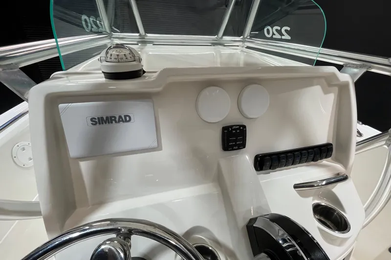 Slide: The Image of 2023 Sailfish 220 CC boat dashboard with Simrad display and compass. - 9