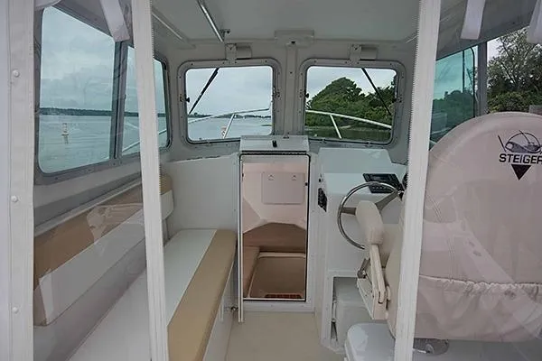 Slide: The Image of 2026 Steiger Craft 21 Miami boat interior with helm, seating, and windows overlooking water. - 7