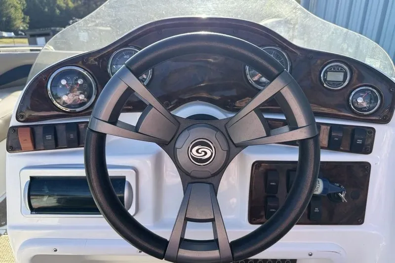 Slide: The Image of 2015 Hurricane SunDeck Sport 202 IO boat dashboard with steering wheel and gauges. - 14