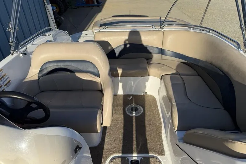 Slide: The Image of 2015 Hurricane SunDeck Sport 202 IO boat interior with beige seating and steering wheel. - 15