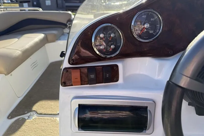 Slide: The Image of 2015 Hurricane SunDeck Sport 202 IO dashboard with gauges and controls. - 22