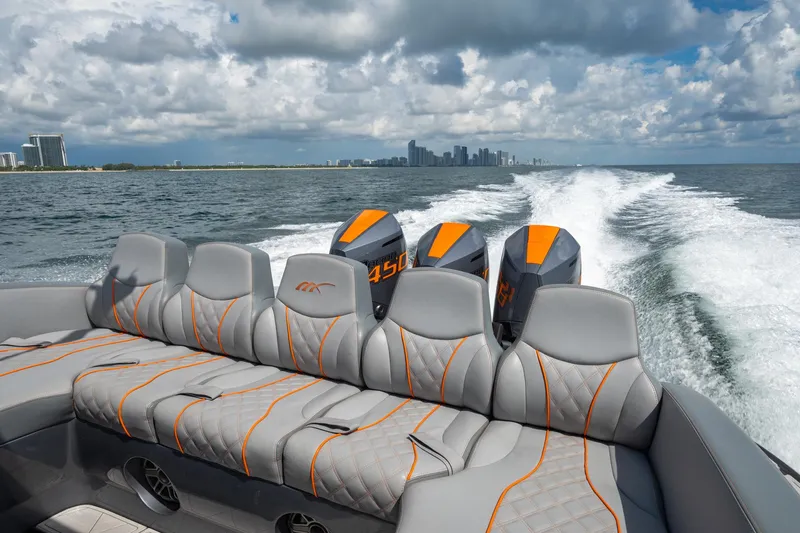 Slide: The Image of 2022 Midnight Express 37' Open boat cruising with powerful engines, city skyline in background. - 10
