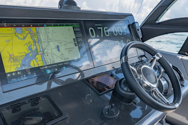 Slide: The Image of 2022 Midnight Express 37' Open boat dashboard with navigation screens and steering wheel. - 19
