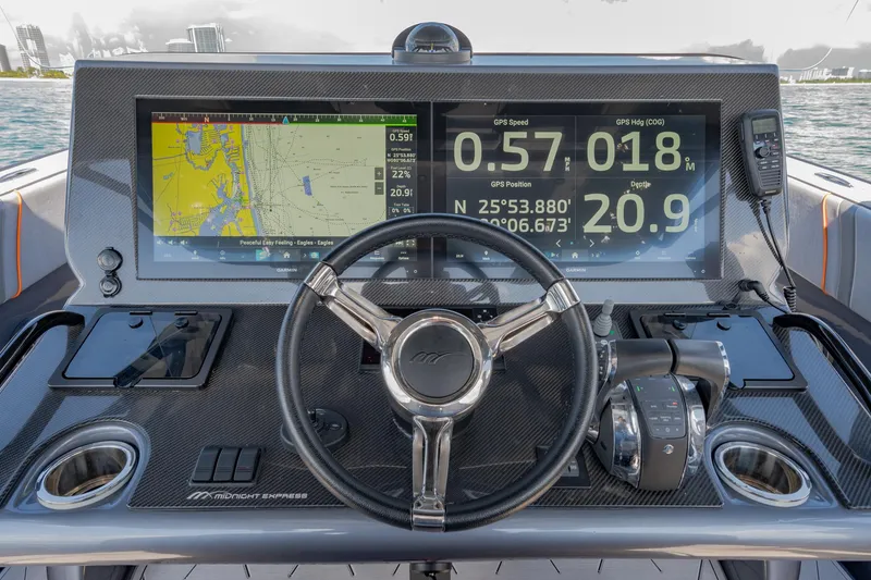 Slide: The Image of 2022 Midnight Express 37' Open boat dashboard with navigation screens and steering wheel. - 21