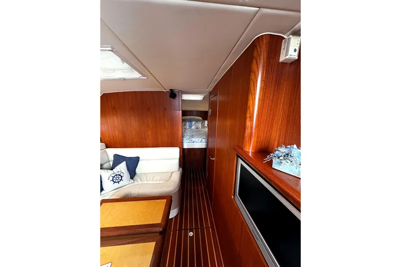 Slide: The Image of Interior of 2004 Tiara Yachts 4200 Open, featuring wood paneling and comfortable seating. - 11
