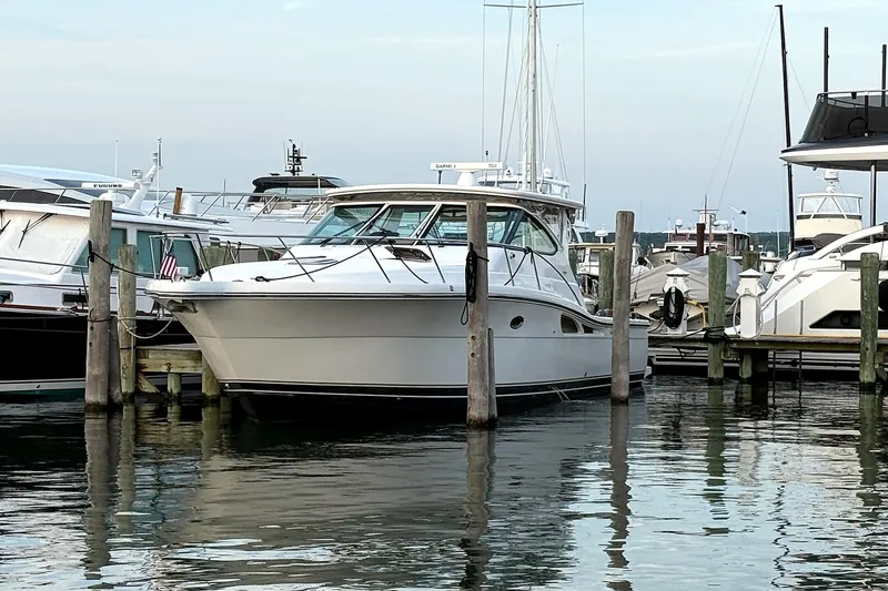 Slide: The Image of 2004 Tiara Yachts 4200 Open docked at a marina, surrounded by other boats. - 23
