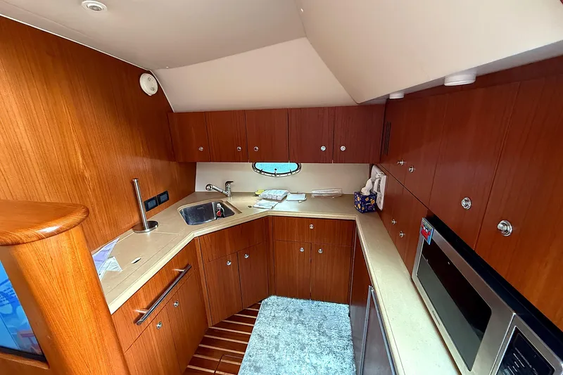 Slide: The Image of 2004 Tiara Yachts 4200 Open galley with wood cabinetry and modern appliances. - 3