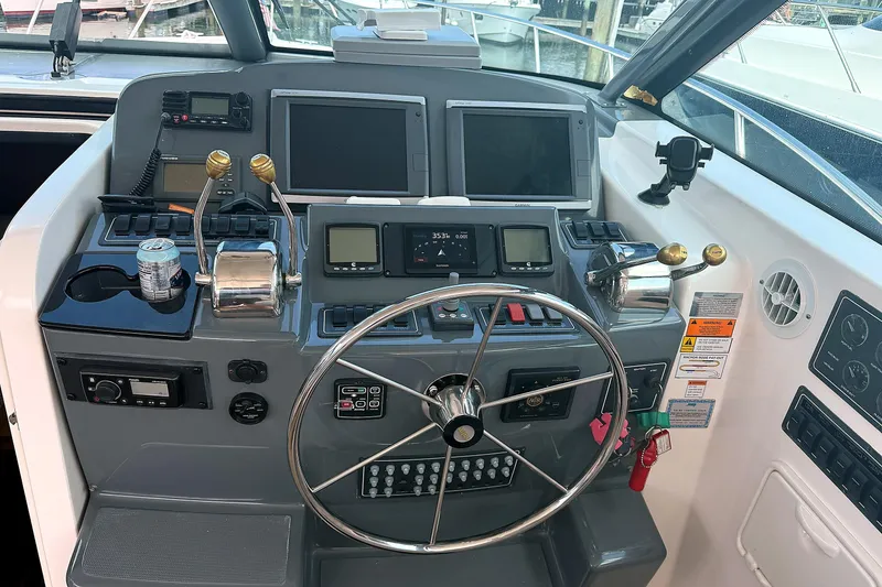 Slide: The Image of Helm of 2004 Tiara Yachts 4200 Open with steering wheel and navigation controls. - 7