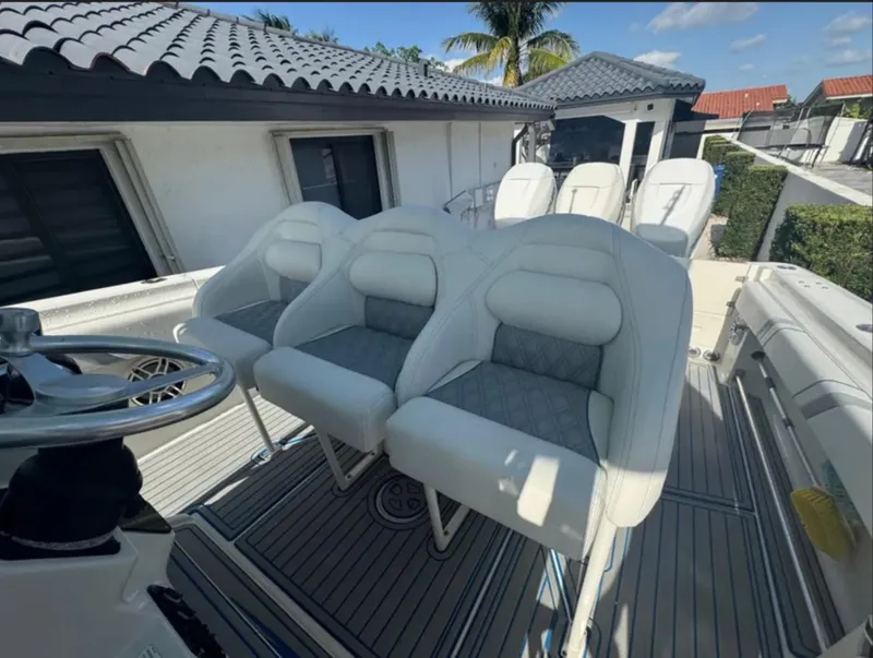 Slide: The Image of 2004 Hydra-Sports Vector 33 CC boat with white cushioned seats and steering wheel. - 7