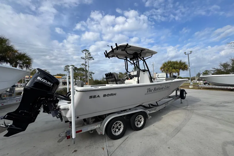 Slide: The Image of 2022 Sea Born LX24 Center Console boat on trailer under cloudy sky. - 10