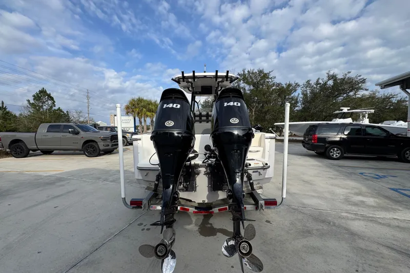 Slide: The Image of 2022 Sea Born LX24 Center Console boat with twin 140 horsepower engines in a parking lot. - 12