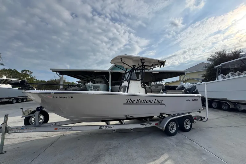 Slide: The Image of 2022 Sea Born LX24 Center Console boat on trailer under cloudy sky. - 2