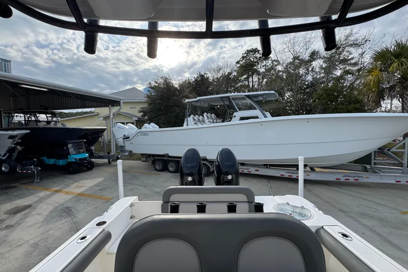 Slide: The Image of 2022 Sea Born LX24 Center Console boat in a marina, surrounded by other vessels. - 26