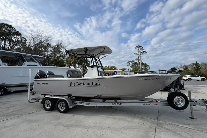 Slide: The Image of 2022 Sea Born LX24 Center Console boat on trailer, parked outdoors under cloudy sky. - 8