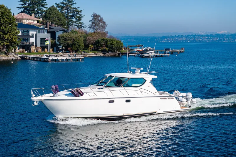 Slide: The Image of 2006 Tiara Yachts 4300 Sovran cruising on a scenic lake near waterfront homes. - 1
