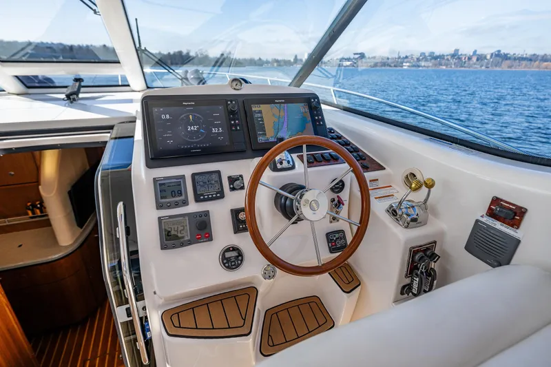 Slide: The Image of Helm of 2006 Tiara Yachts 4300 Sovran, featuring advanced navigation controls and wooden steering wheel. - 15