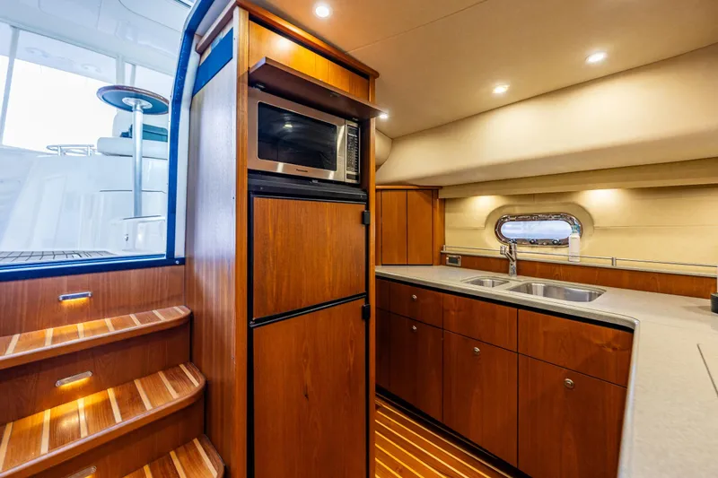 Slide: The Image of Luxurious 2006 Tiara Yachts 4300 Sovran interior with modern kitchen and wooden cabinetry. - 19