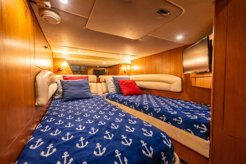 Slide: The Image of Luxurious 2006 Tiara Yachts 4300 Sovran cabin with twin beds and nautical-themed decor. - 28