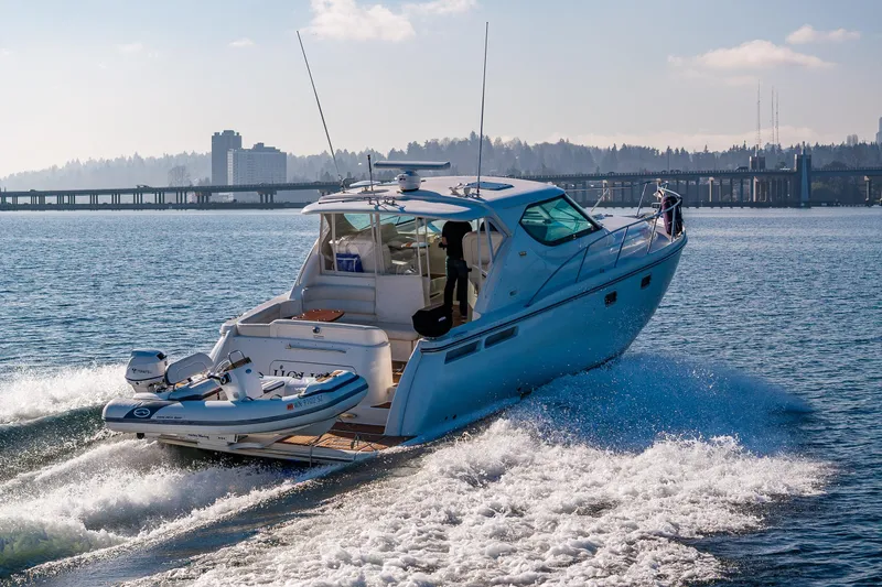 Slide: The Image of 2006 Tiara Yachts 4300 Sovran cruising on a sunny day near a cityscape. - 5