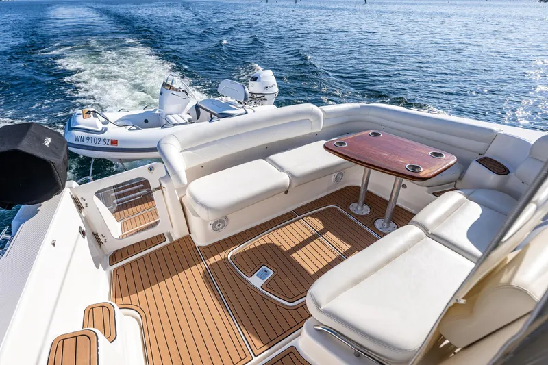 Slide: The Image of 2006 Tiara Yachts 4300 Sovran deck with seating and table, cruising on open water. - 8