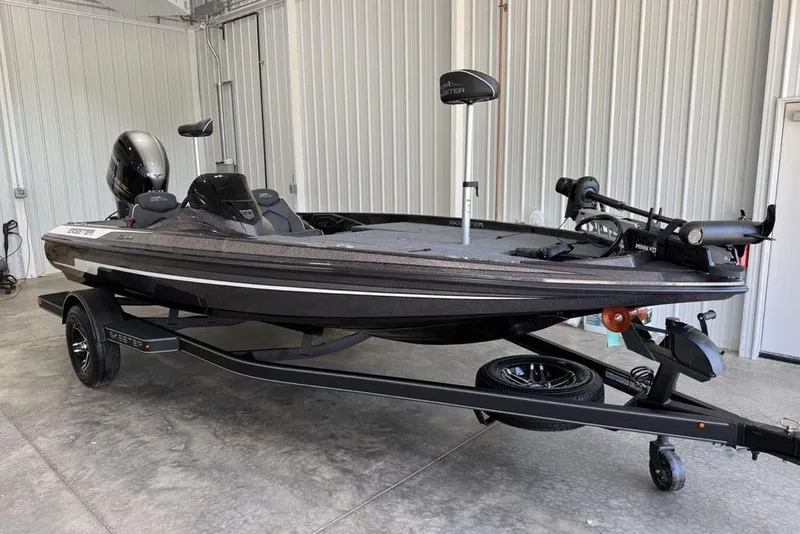 Slide: The Image of 2025 Skeeter ZX150 bass boat on trailer in garage setting. - 2