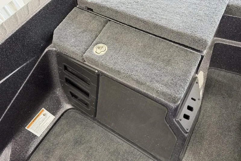 Slide: The Image of Interior of 2025 Skeeter ZX150 boat showing storage compartment and carpeted flooring. - 8