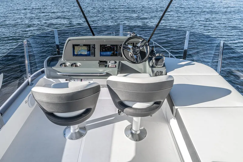 Slide: The Image of 2024 Bavaria R40 yacht helm with dual seats and navigation screens on open water. - 25