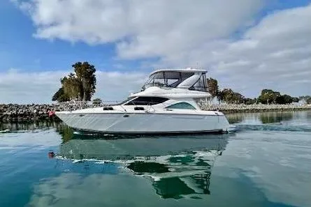 The Image of 2001 Maxum 4600 SCB Limited Edition yacht on calm water, under a partly cloudy sky. - 0